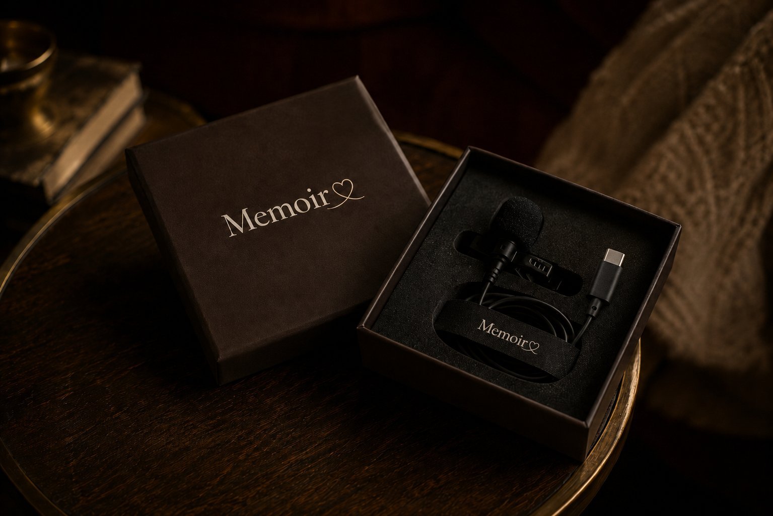 A Memoir-branded keepsake box on a wooden side table, opened to reveal a studio-grade lavalier microphone.